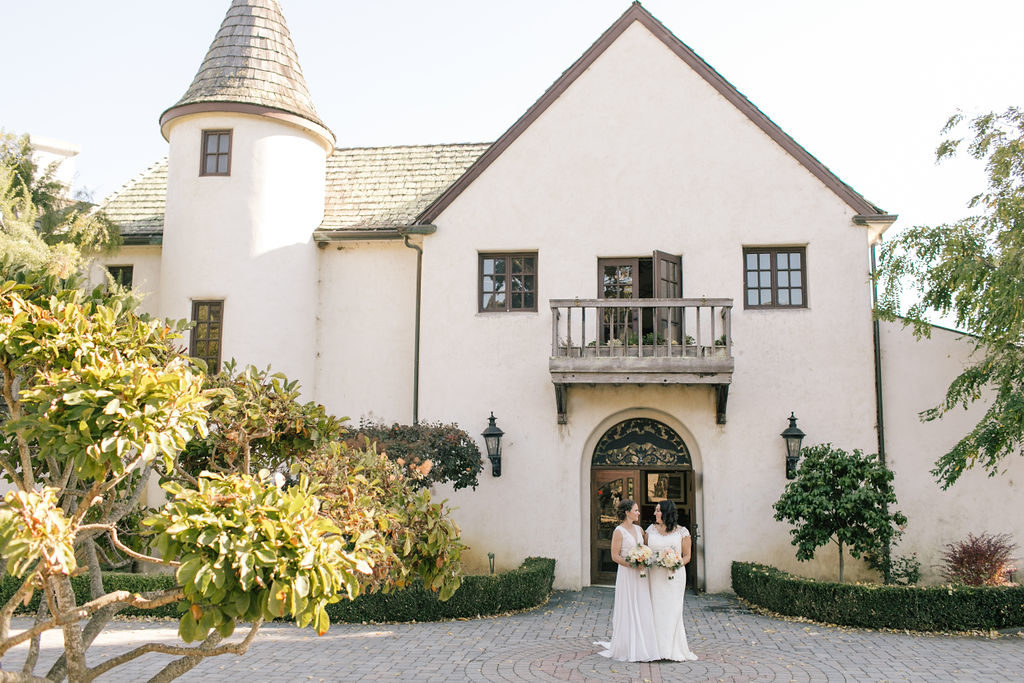 two brides in front of the main winery building at Folktale Winery in Carmel