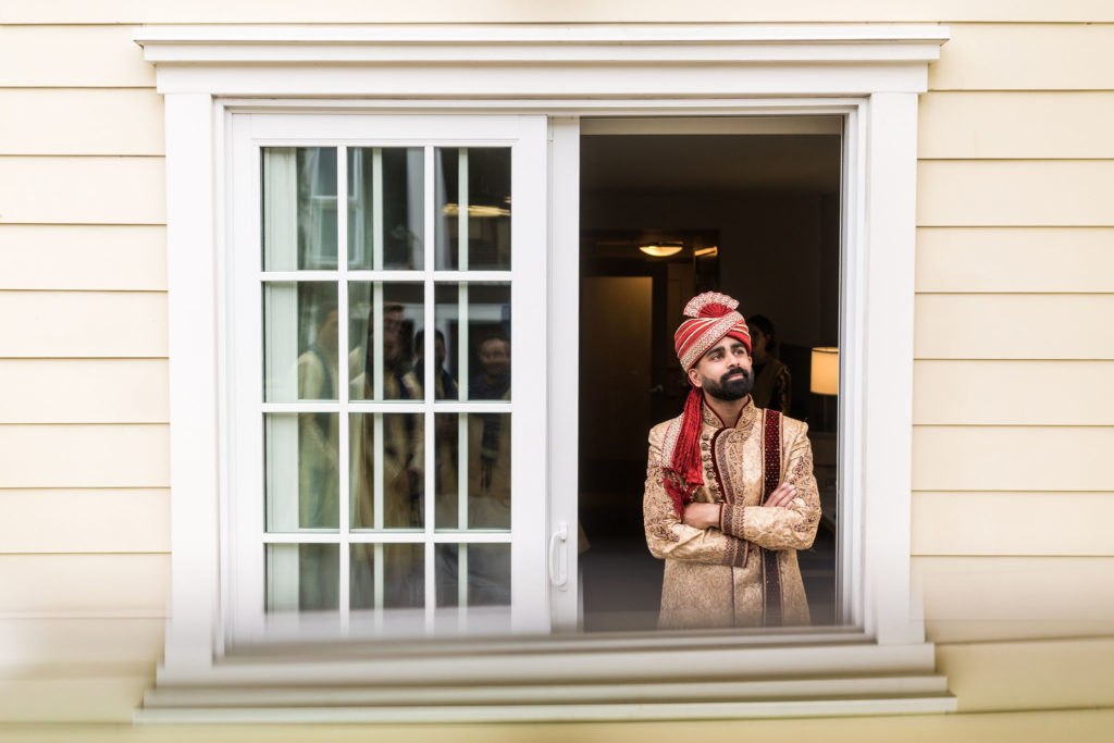 Indian Groom looking out window with red turban