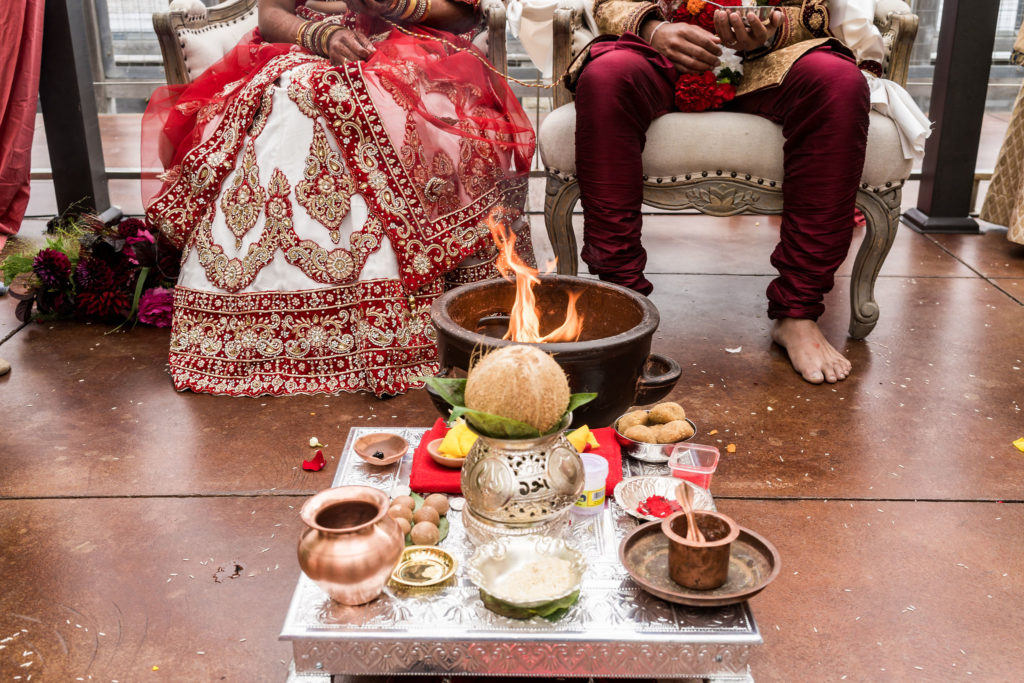 Indian bride and groom in front of fire pot for indian pooja at wedding