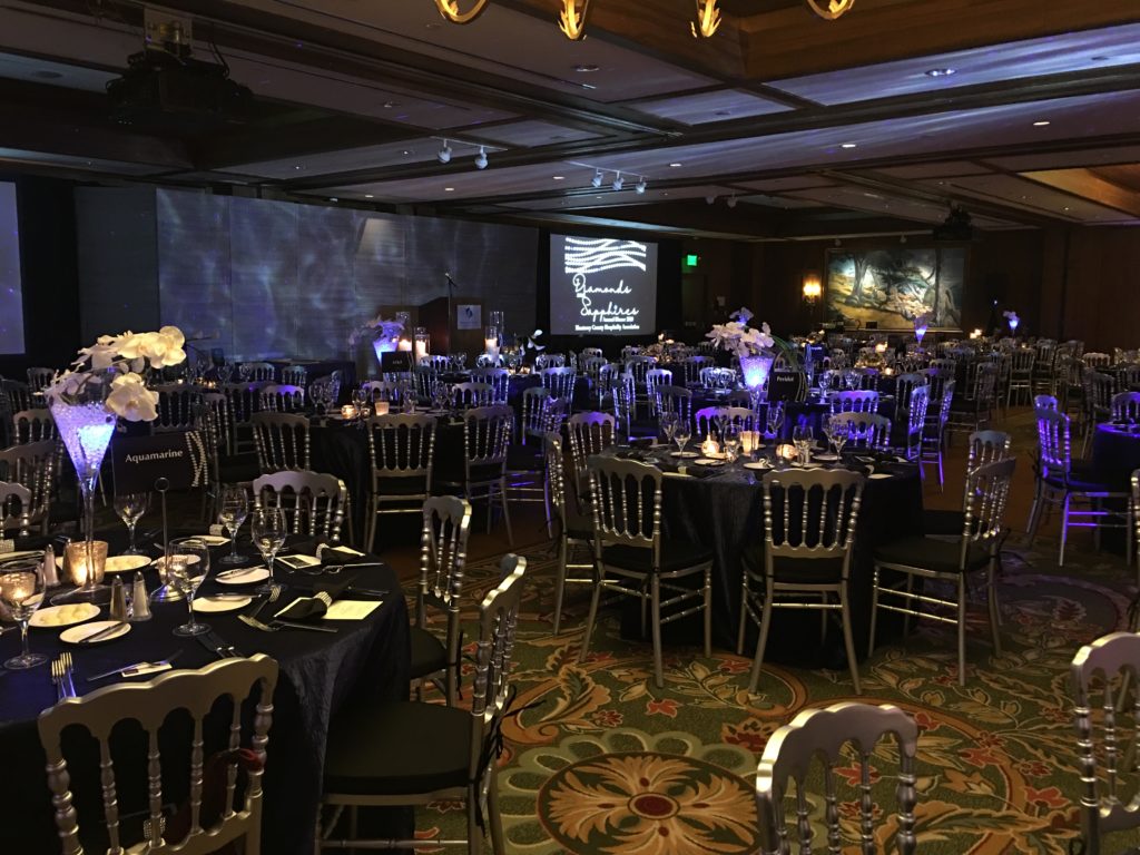 Corporate event in a ballroom set for 300 people with glowing lights and elegant decor