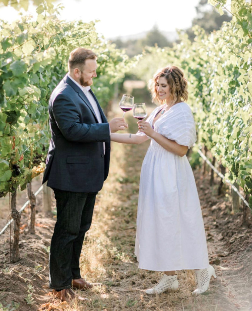 couple toasting with wine glasses in vineyard at bernardus winery in carmel valley