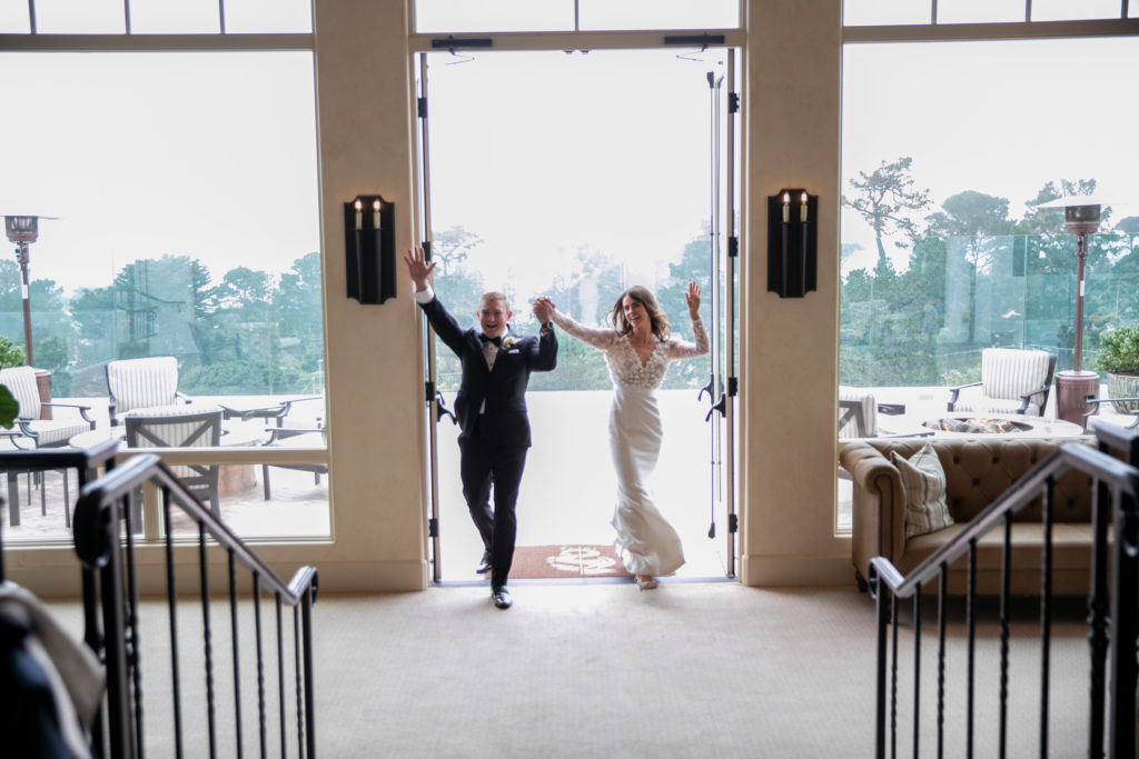 Bride and groom entering their wedding reception celebrating with enthusiasm in Pebble Beach California