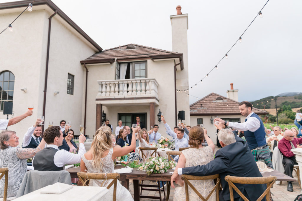 Guests toasting to a couple recently married in an intimate vineyard house setting in Carmel Valley CA