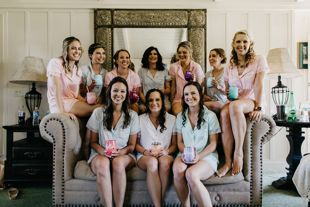 Bride surrounded by bridesmaids during their getting hair and make up time