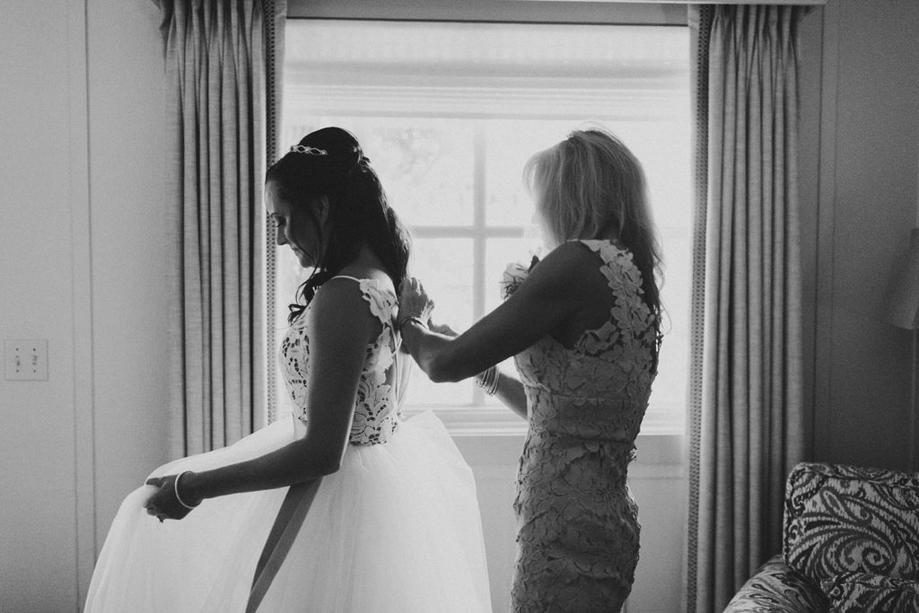 Mother of the Bride tying up Brides Dress on wedding day