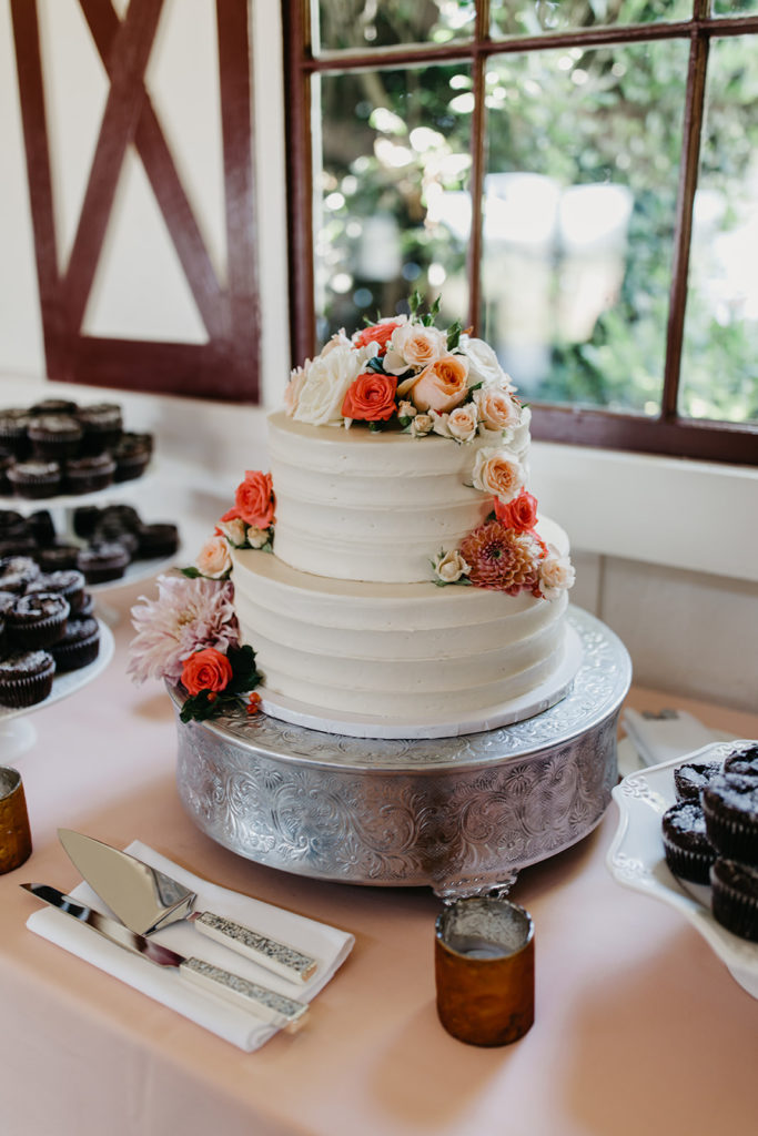 Cake with Oragne and coral florals on dessert table