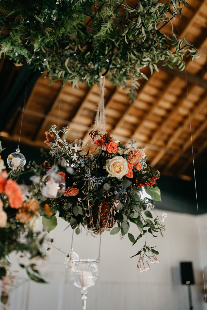 Hanging potted plant arrangement over head table for wedding