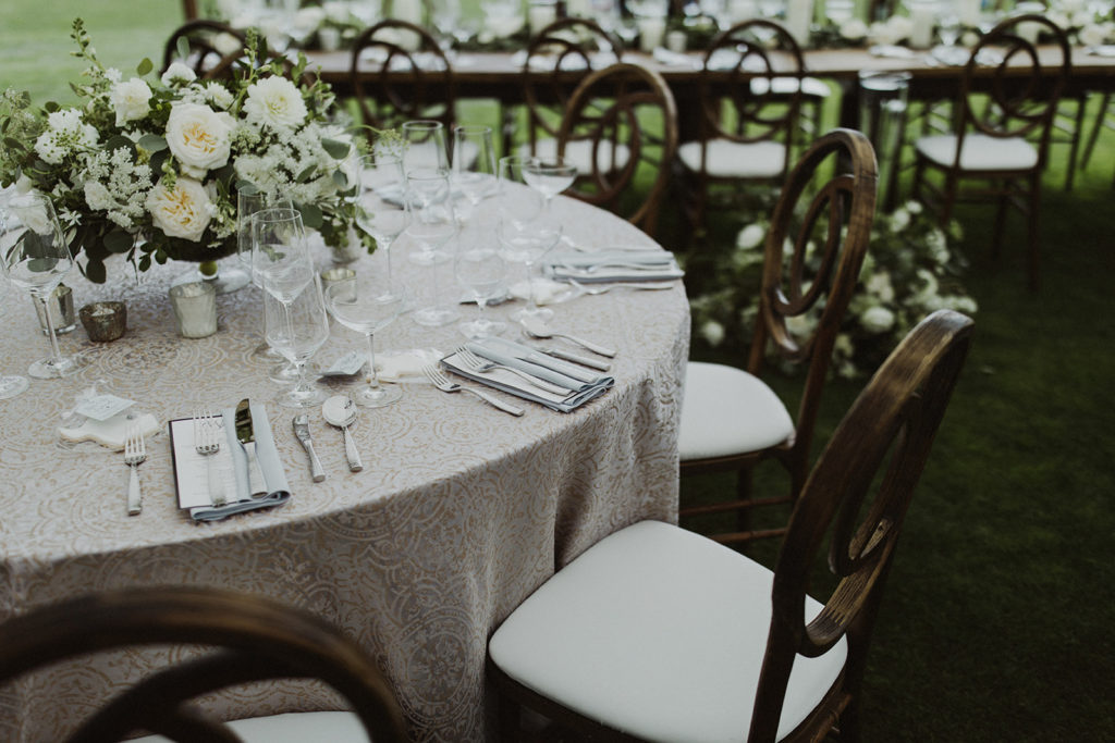 Table with fine linen and white and green wedding flowers