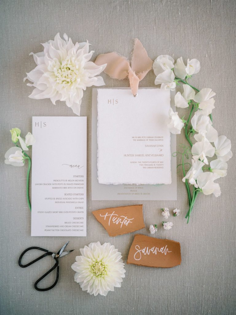 Stationary flat lay styled with flowers and terracotta place cards
