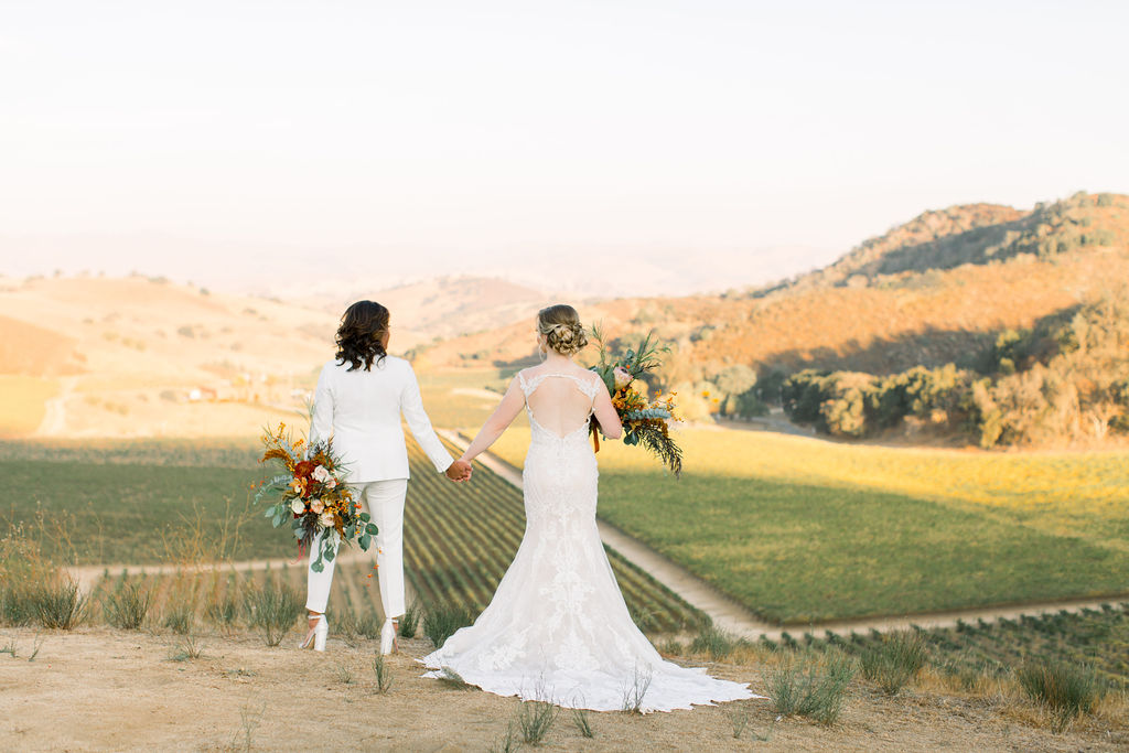 same sex wedding couple standing at the top of Eden Rift overlooking the vineyard on wedding day