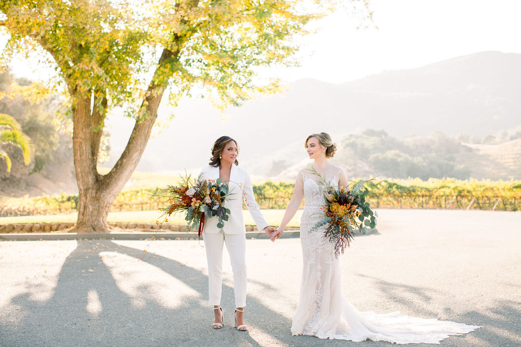 Same sex female couple holding hands posing for gay wedding photo