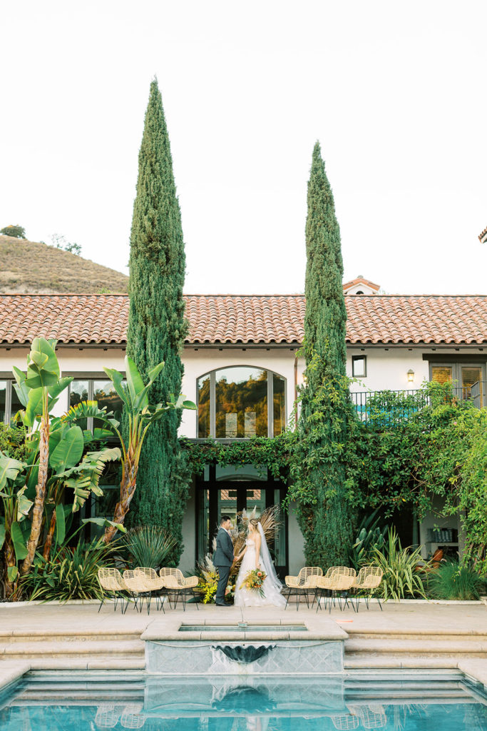 Wedding Ceremony at private estate with hacienda style house and pool. De Tierra Events in Monterey