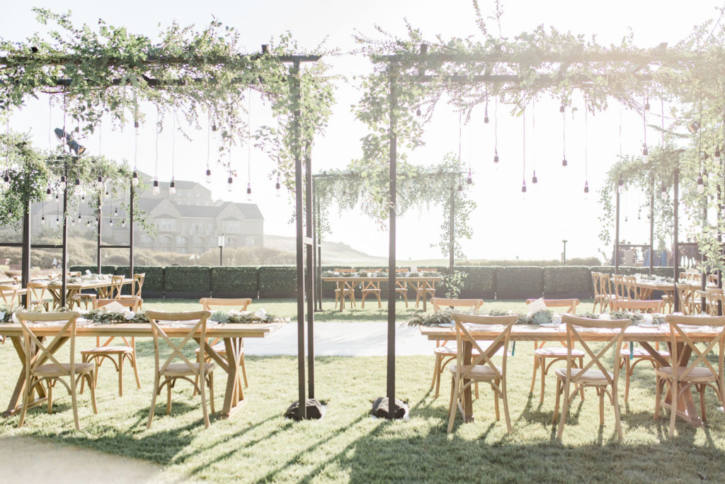 Wooden Reception Tables with Greenery Arches